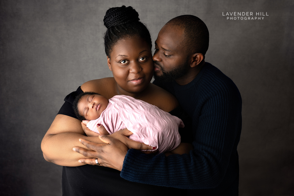 family photographer north east london, dad cuddling ahis wife and a newborn baby 
