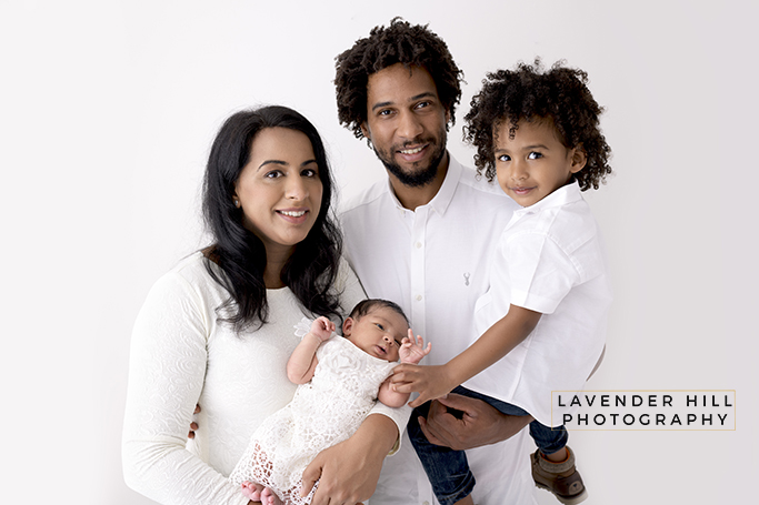 family photography london, family of four with a newborn baby cuddling a newborn baby